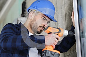 Man drilling window frame