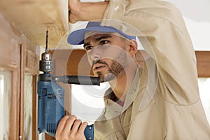 man drilling wood frame