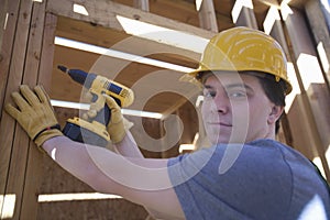 Man Drilling On A Wooden Beam At Site