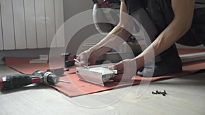 A man drills a metal surface with a drill, close-up.