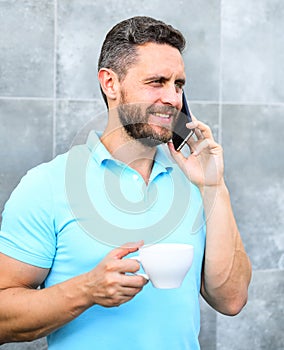 Man drink cappuccino speak phone grey wall background. Coffee can be endlessly reimagined make something old new again