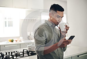 Man, drink and coffee in kitchen with smartphone for trending updates or popular topics on social media or internet