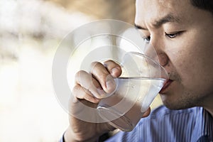 Man drink fresh cold pure water in glass