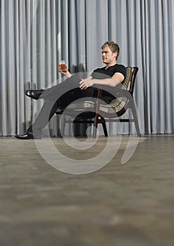 Man With Drink Sitting On Chair