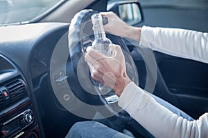 Man drinking alcohol while driving a car.