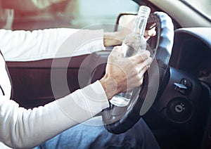 Man drinking alcohol while driving a car