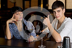 Man drinking at a bar giving a thumbs up