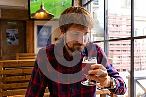 The man is drinking beer at the bar. A man is depressed, struggling with alcohol addiction. Crisis, unemployment, loneliness