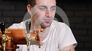 Man drinking beer and enjoying beverage at pub bar HD close-up slow-motion video. Male guest tastes lager from glasses