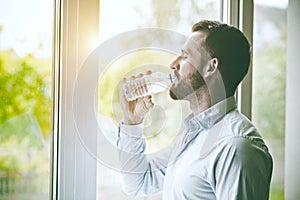 man drinking bottle of water