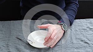 Man drinking coffee at the table. Selective focus.