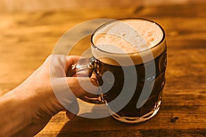 Man drinking dark beer in british dimpled glass pint mug