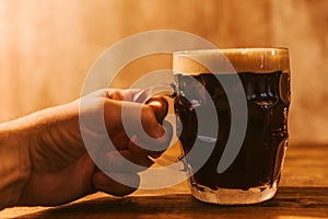 Man drinking dark beer in british dimpled glass pint mug