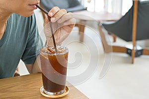 Man drinking a glass of ice americano. photo