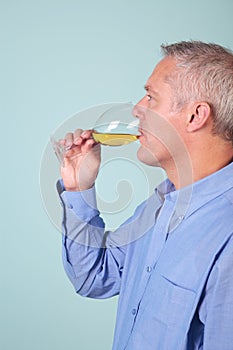 Man drinking a glass of white wine