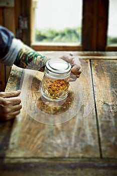 Man drinking a large mug of beer in a rustic pub