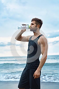 Man Drinking Refreshing Water After Workout At Beach. Drink