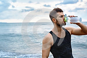 Man Drinking Refreshing Water After Workout At Beach. Drink