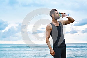 Man Drinking Refreshing Water After Workout At Beach. Drink