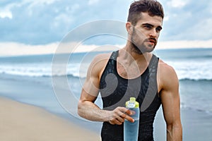 Man Drinking Refreshing Water After Workout At Beach. Drink