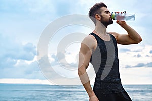 Man Drinking Refreshing Water After Workout At Beach. Drink