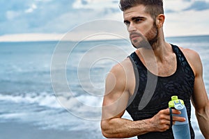 Man Drinking Refreshing Water After Workout At Beach. Drink