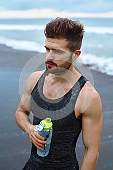 Man Drinking Refreshing Water After Workout At Beach. Drink