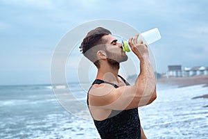 Man Drinking Refreshing Water After Workout At Beach. Drink