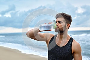 Man Drinking Refreshing Water After Workout At Beach. Drink