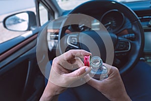 Man drinking vodka in his car. Drunk driver. Drinking alcohol in automobile