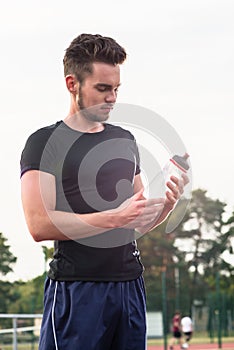 Man drinking from water bottle during sports