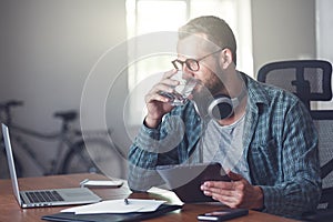 Man drinking water with digital tablet