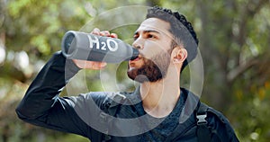 Man drinking water hiking in a forest, nature or woods outdoors in jungle adventure with freedom in Costa Rica. Healthy