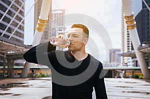 Man drinking water after running exercise at the city