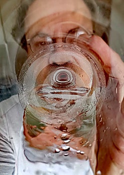 The man drinks cold water directly from the bottle.
