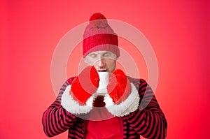 A man drinks a hot drink. Cold weather. Red background