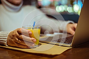 Man drinks juse while working on laptop
