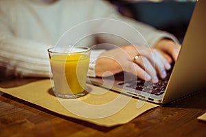 Man drinks juse while working on laptop