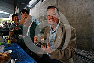 Man Drinks tea from Beer Mug in Luang Prubang, Laos