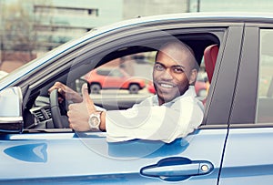 Man driver happy smiling showing thumbs up driving sport blue car