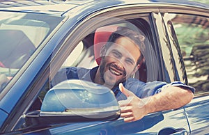 Man driver happy smiling showing thumbs up driving sport car