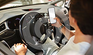 Man driver holding mobile phone with white blank screen