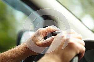 Man driver`s hands on the steering wheel.Driver`s hands. Male hands on the steering wheel while driving a car