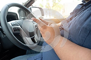 Man driver using mobile phone when driving car on road. people hand holding smart phone driving car, dangerous accident concept