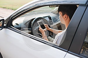 Man driver using smart phone in car