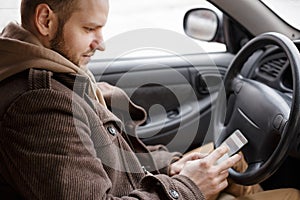 Man driver using smart phone in car, internet technology communication on road