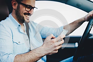 Man driver using smart phone in car modern