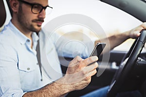 Man driver using smart phone in car modern