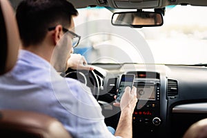 Man driver using smart phone in car modern