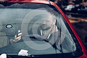 Man driver using smart phone in car, modern internet technology communication concept